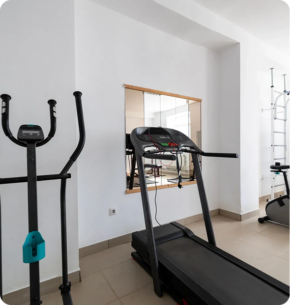 Gym with treadmill and exercise equipment.