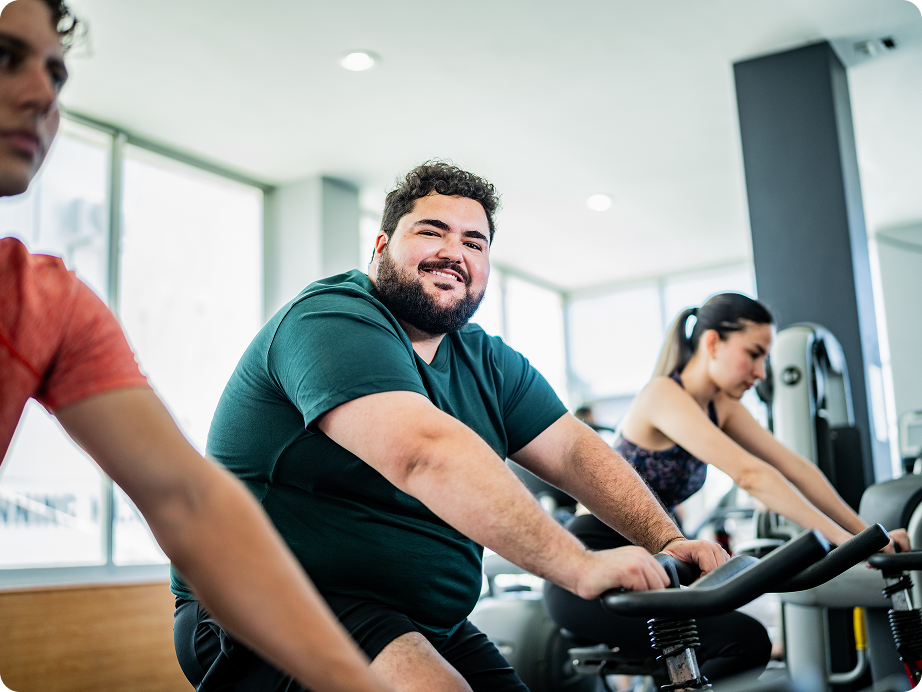 People exercising on stationary bikes at gym.